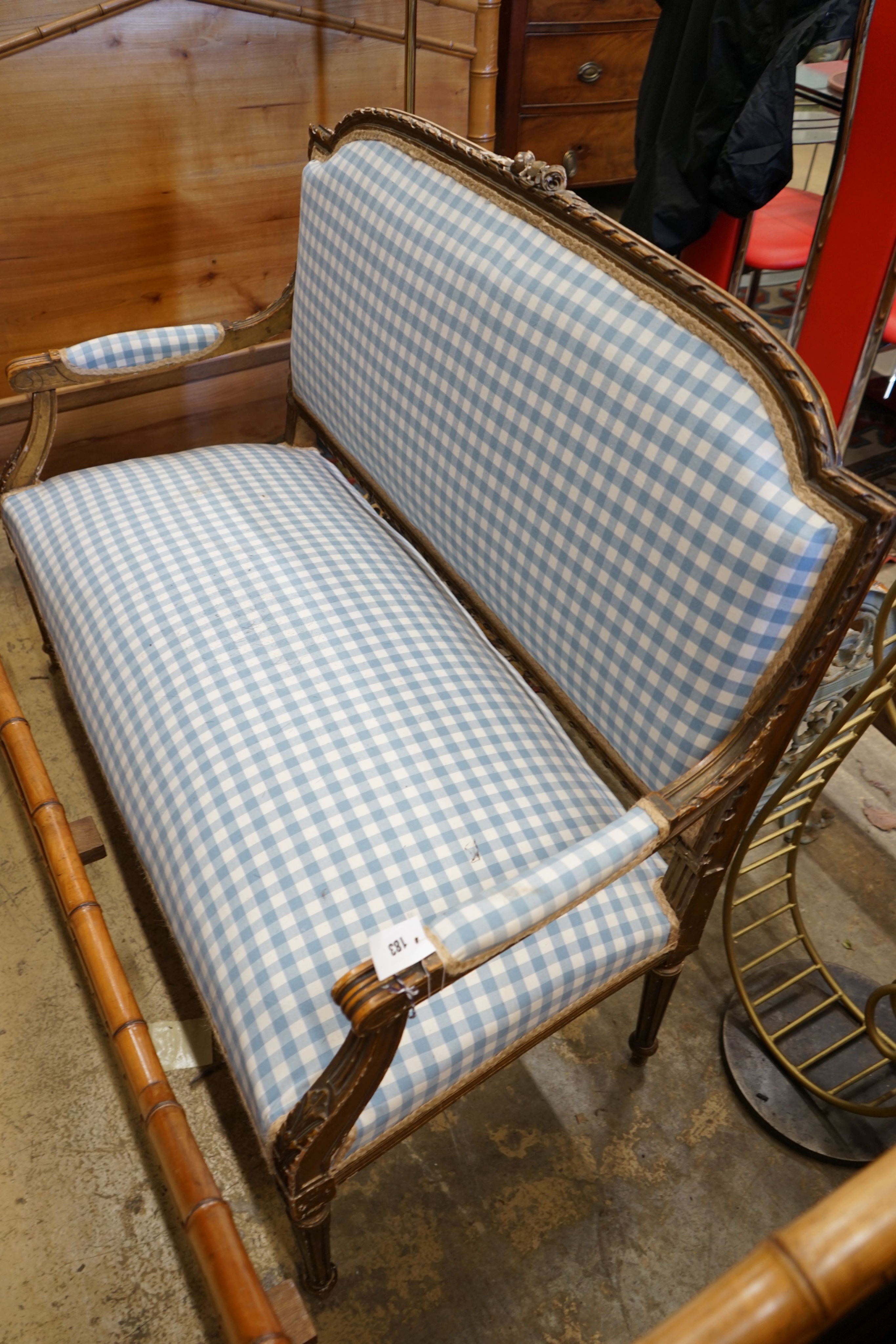 A 19th century French carved giltwood settee recently re-upholstered in blue gingham fabric, width 130cm depth 55cm height 102cm